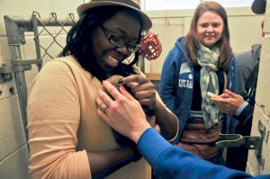 Student Chelsea Johnson pets a greyhound pup while Amanda Gambill looks on. Photo by Ray Wong.